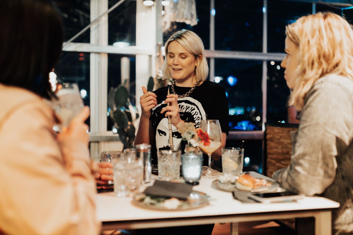 Une femme souriante à une table de brunch.